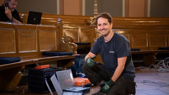 smilende AV tekniker i et auditorium